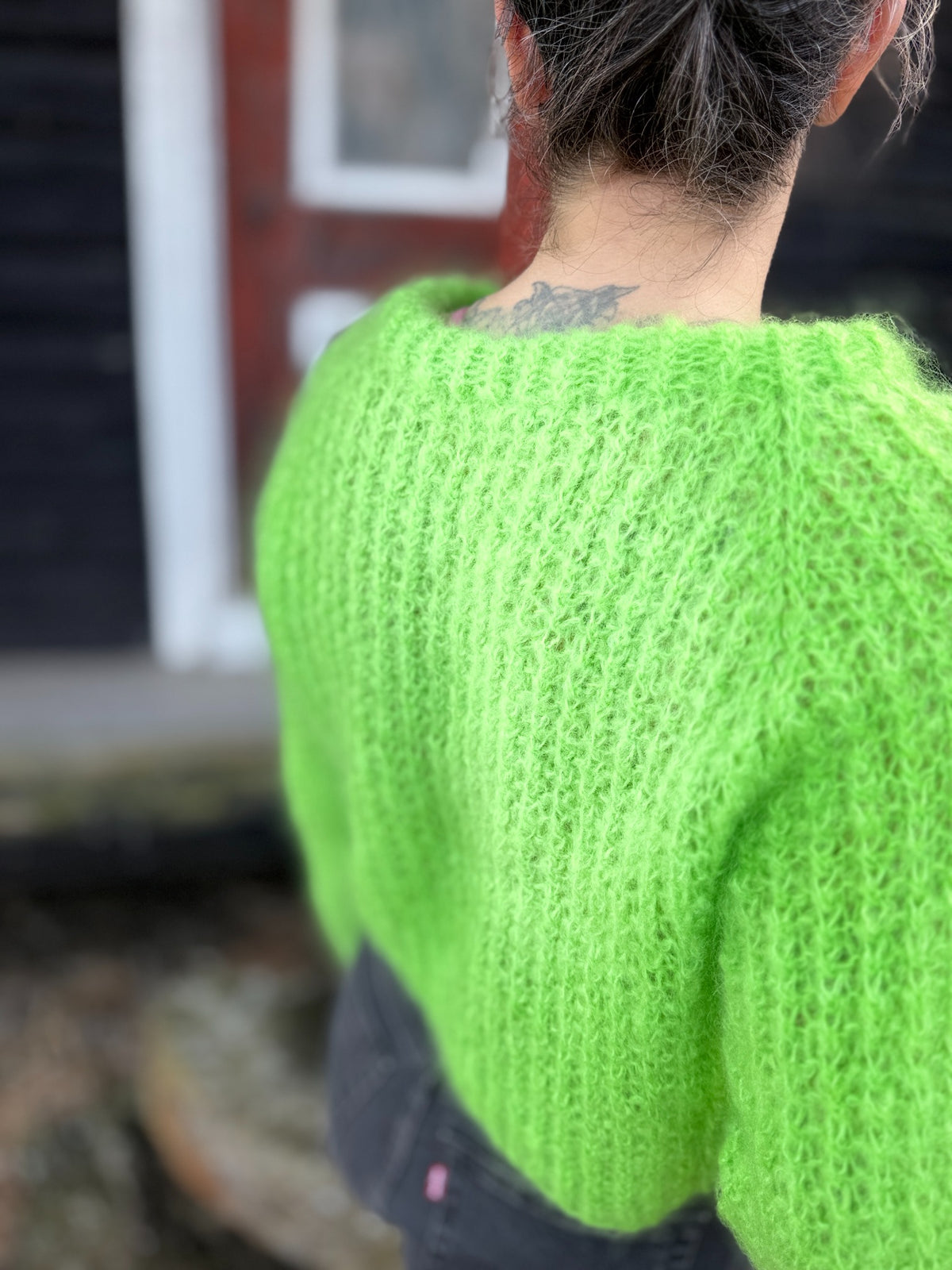 Detalj av hals og strukturmønster på grønn Mrs. Sweater